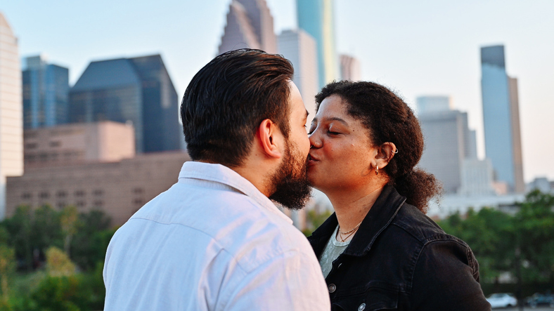 American young couple enjoying sunset in the city, with beautiful skyline in the background