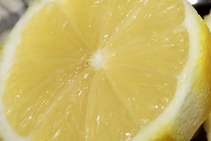 Close up of Grated Lemon Cut in Half on Chopping Board