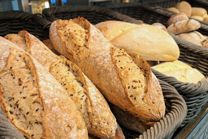 Fresh baguettes on a bakery display. Artisan bread shop with crispy golden loaves.