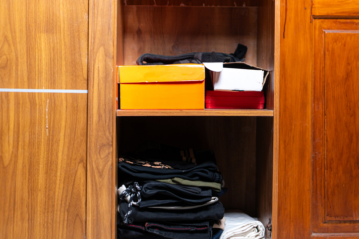 Organized Wooden Shelf with Clothes and Storage Boxes