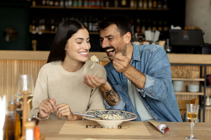 Loving couple eating spaghetti at the restaurant