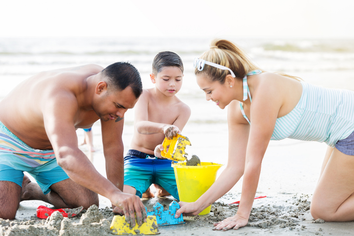 Happy family builds sand castle