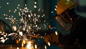 Welder welding steel in workshop.