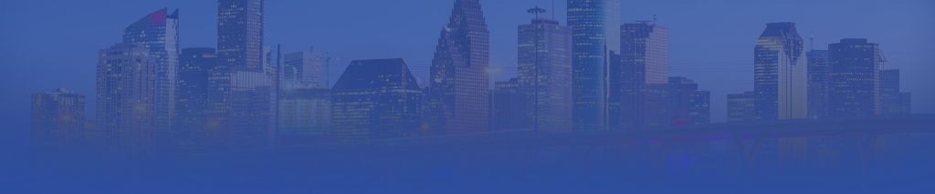 Skyline of a major city at night, with tall skyscrapers and illuminated buildings against a dark blue sky.