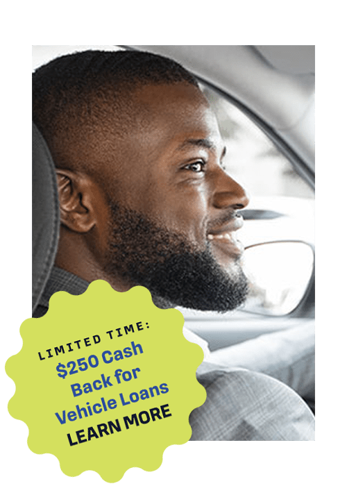 A man with a beard and short hair sitting in the driver's seat of a car, looking out the windshield. Text overlay: "Limited Time: $250 Cash Back for Vehicle Loans LEARN MORE".