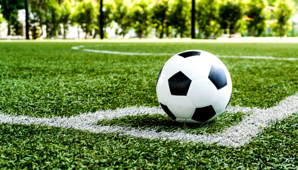 A soccer ball on a grassy field with white boundary lines.