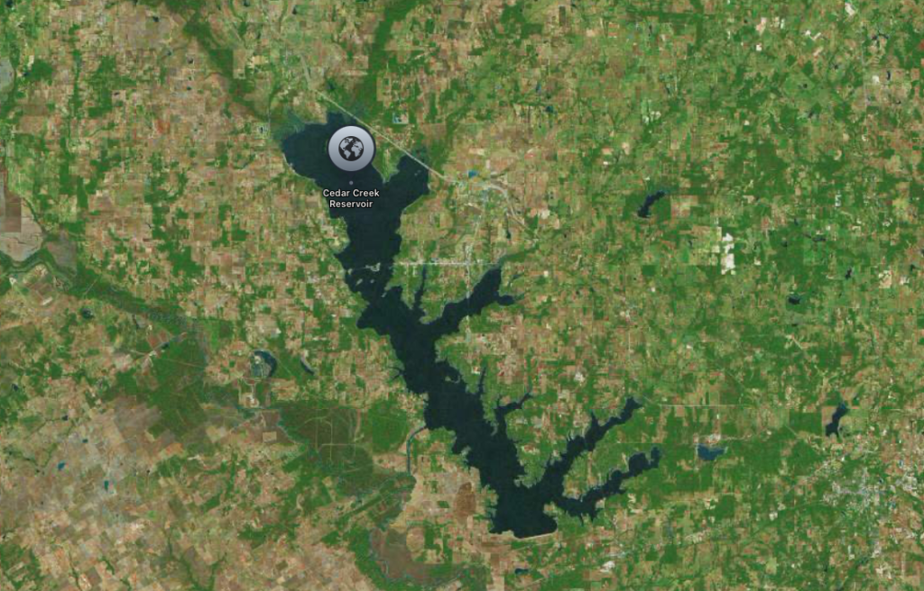 Satellite image of Cedar Creek Reservoir surrounded by lush, green vegetation.