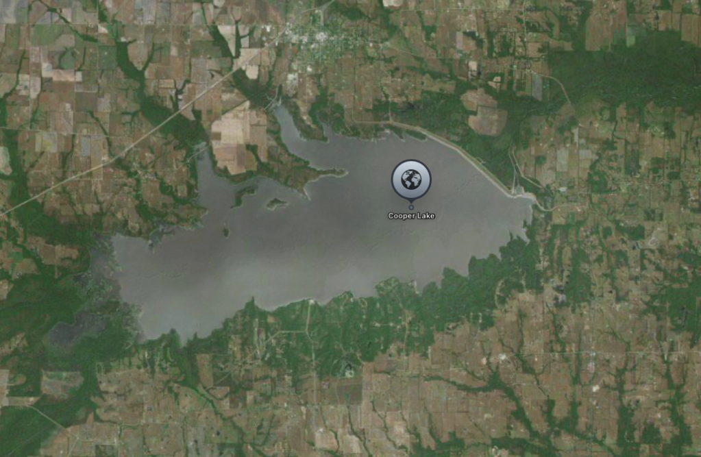 Aerial view of Cooper Lake, a body of water surrounded by rural, forested landscape.