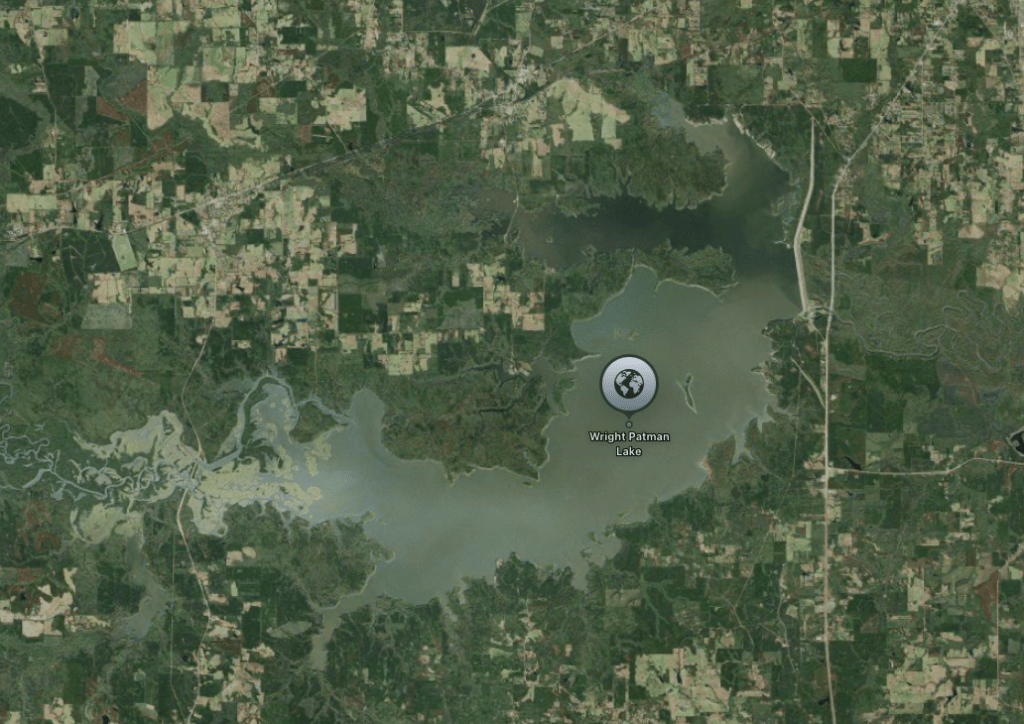 Aerial view of Wright Patman Lake surrounded by forested and agricultural land.