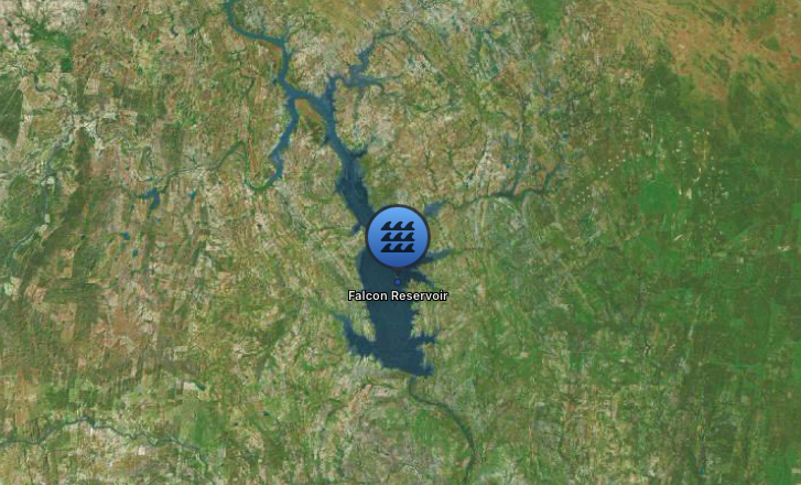 Aerial view of Falcon Reservoir, a large body of water surrounded by forested and rural areas.