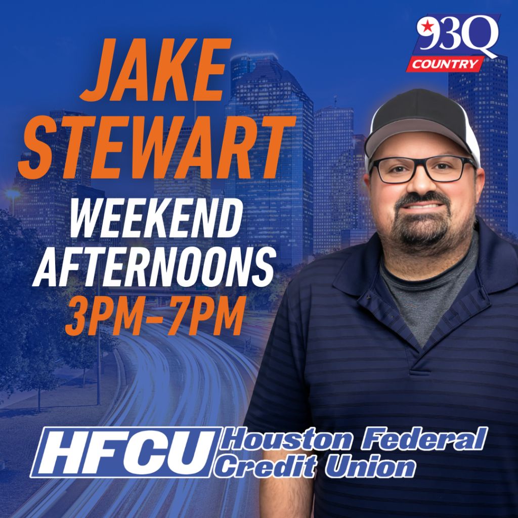 A man with a beard and glasses wearing a baseball cap stands in front of a cityscape. The text "JAKE STEWART" and "WEEKEND AFTERNOONS 3PM-7PM" is displayed, along with the "93Q COUNTRY" logo and "HFCU Houston Federal Credit Union" branding.